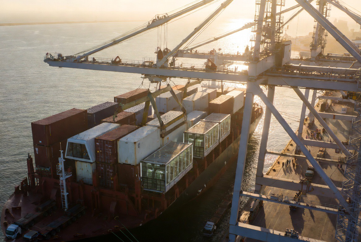Modules lifted off a ship at a port